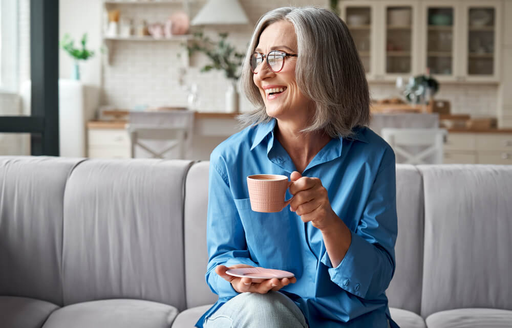 Older woman holding coffee cup and smiling